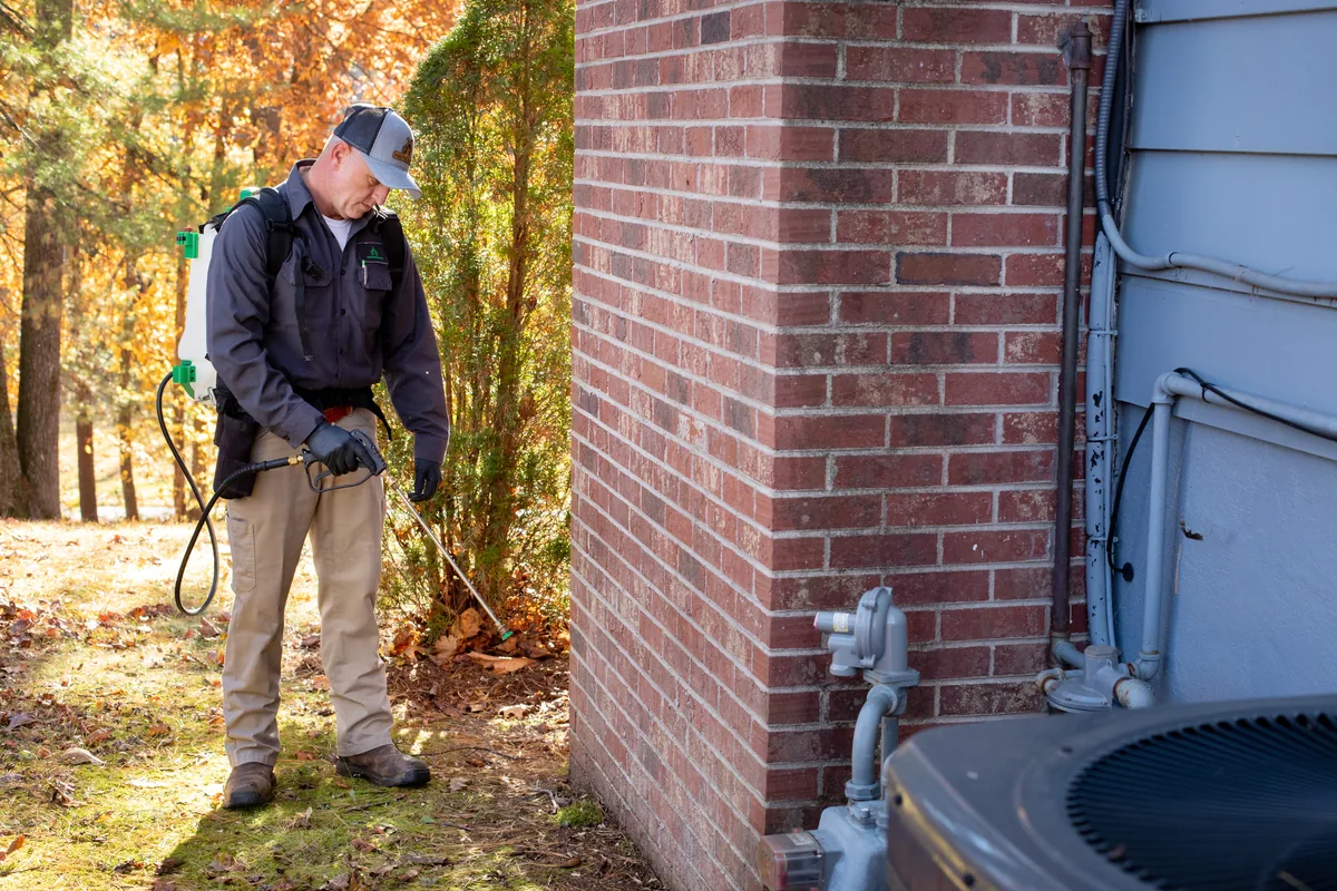 Technician treating exterior foundation